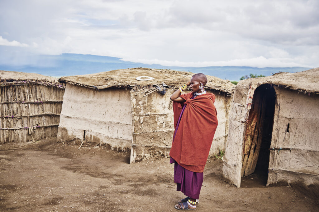 Homme Maasai devant village Maasai en Tanzanie
